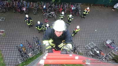 Ein Feuerwehrmann steigt zur Rettung der Personen die Schiebleiter hinauf.